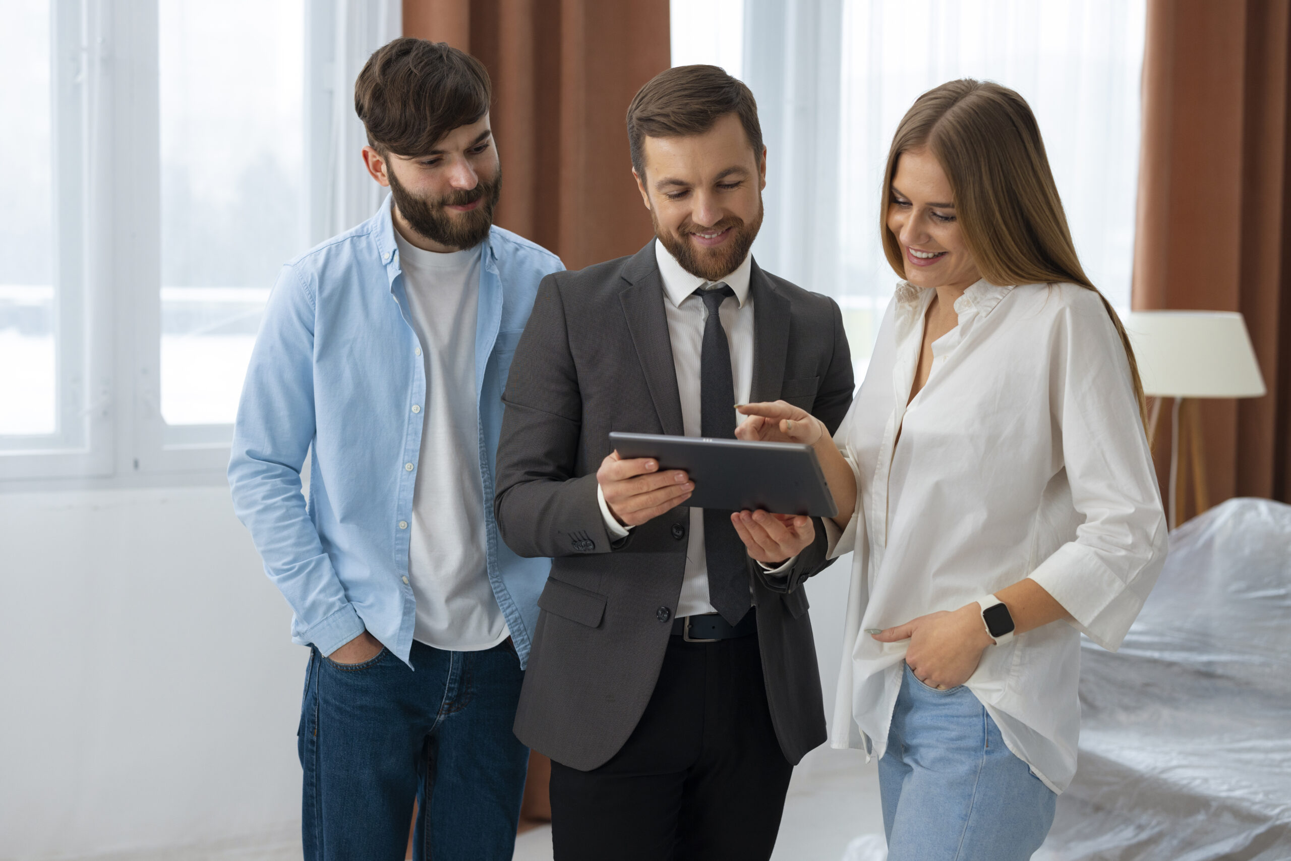 agente-inmobiliario-masculino-haciendo-negocios-y-mostrando-la-casa-una-posible-pareja-compradora